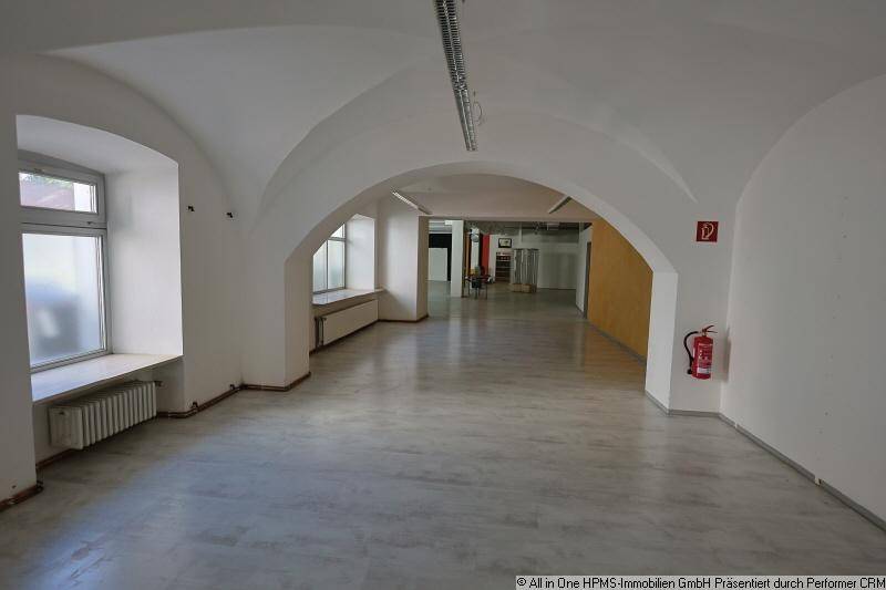 Heller Gewerberaum mit markanten Gewölbedecken und großen Fenstern, die viel Tageslicht hereinlassen.