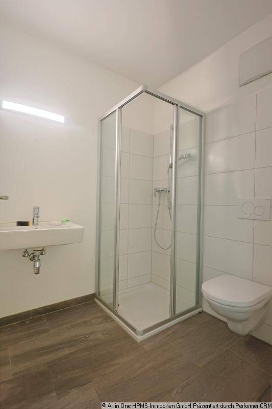 Modernes Badezimmer mit Eckdusche, wandhängendem WC und Einzelwaschbecken.