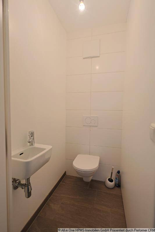 Kleines Gäste-WC mit wandhängendem WC und kompaktem Waschbecken.