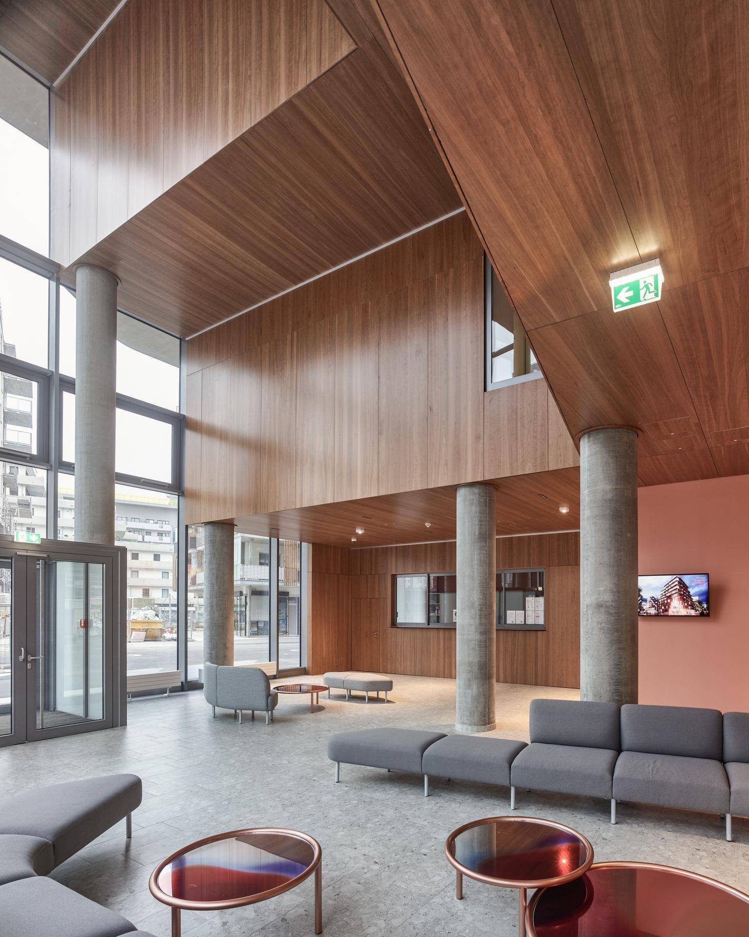 Großzügige, moderne Lobby mit hohen Decken, Holzakzenten und bequemen Sitzgelegenheiten.