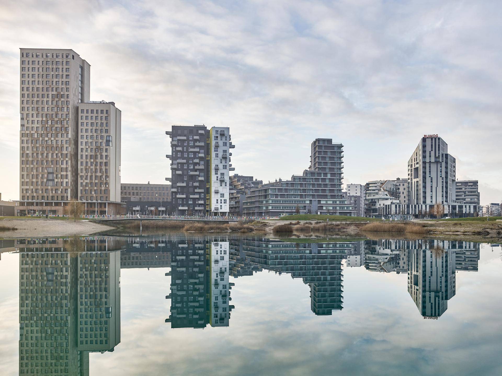Skyline moderner Gebäude spiegelt sich in der ruhigen Wasseroberfläche eines Sees wider.