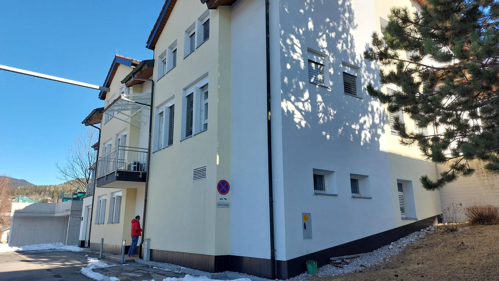 Seitenansicht des Gebäudes an einem sonnigen Wintertag mit Schnee am Boden.