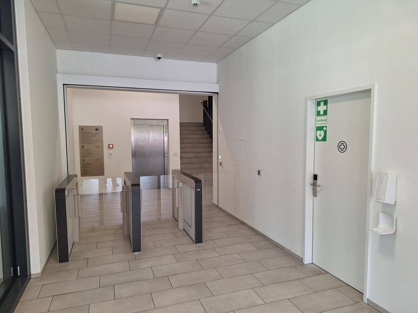 Eingangsbereich mit Drehkreuzen, Aufzug und Treppe, bietet Zugang zu den Büroetagen.