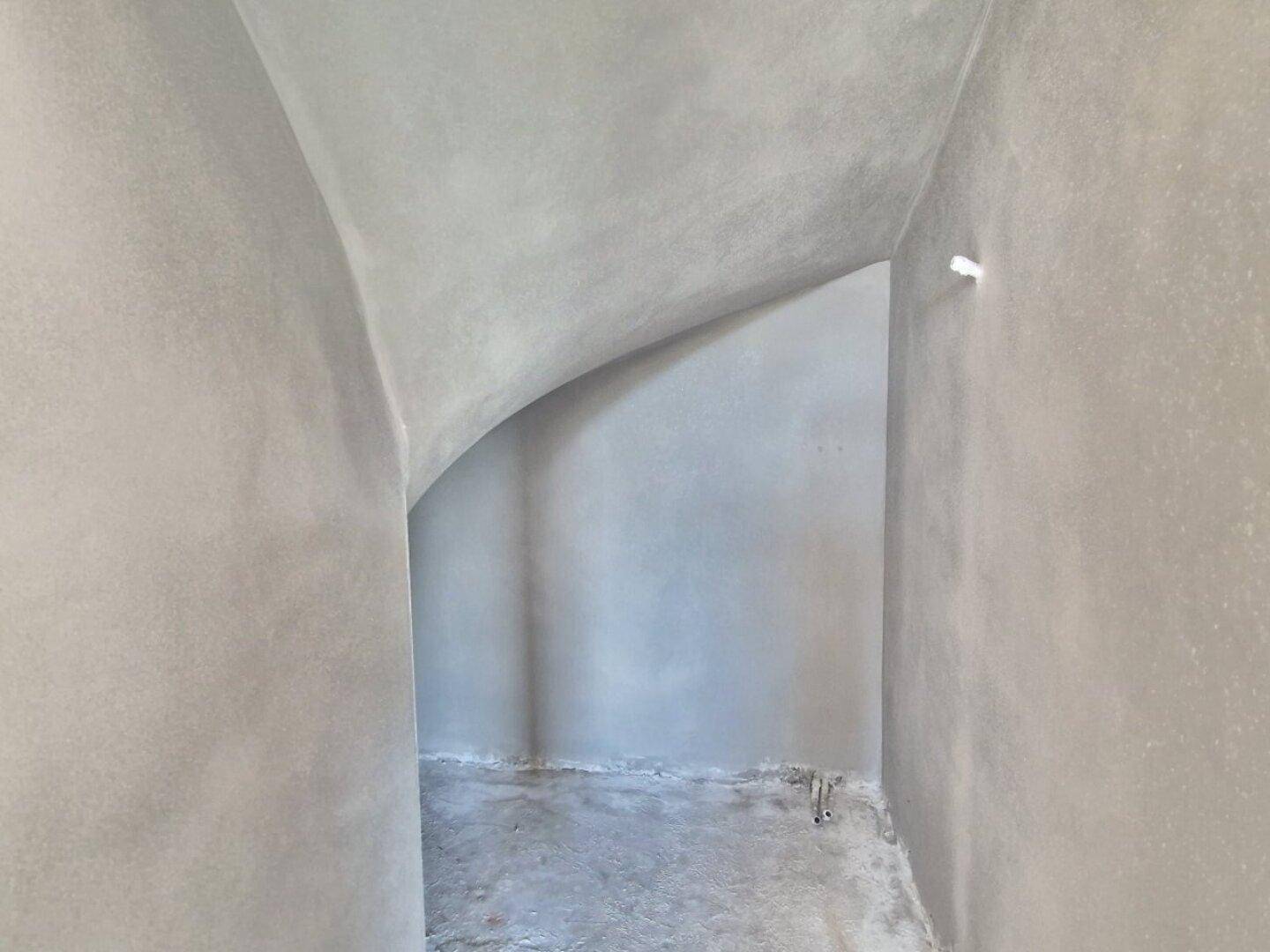Unfertiger Flurbereich mit gewölbter Decke, der auf den Innenausbau wartet.