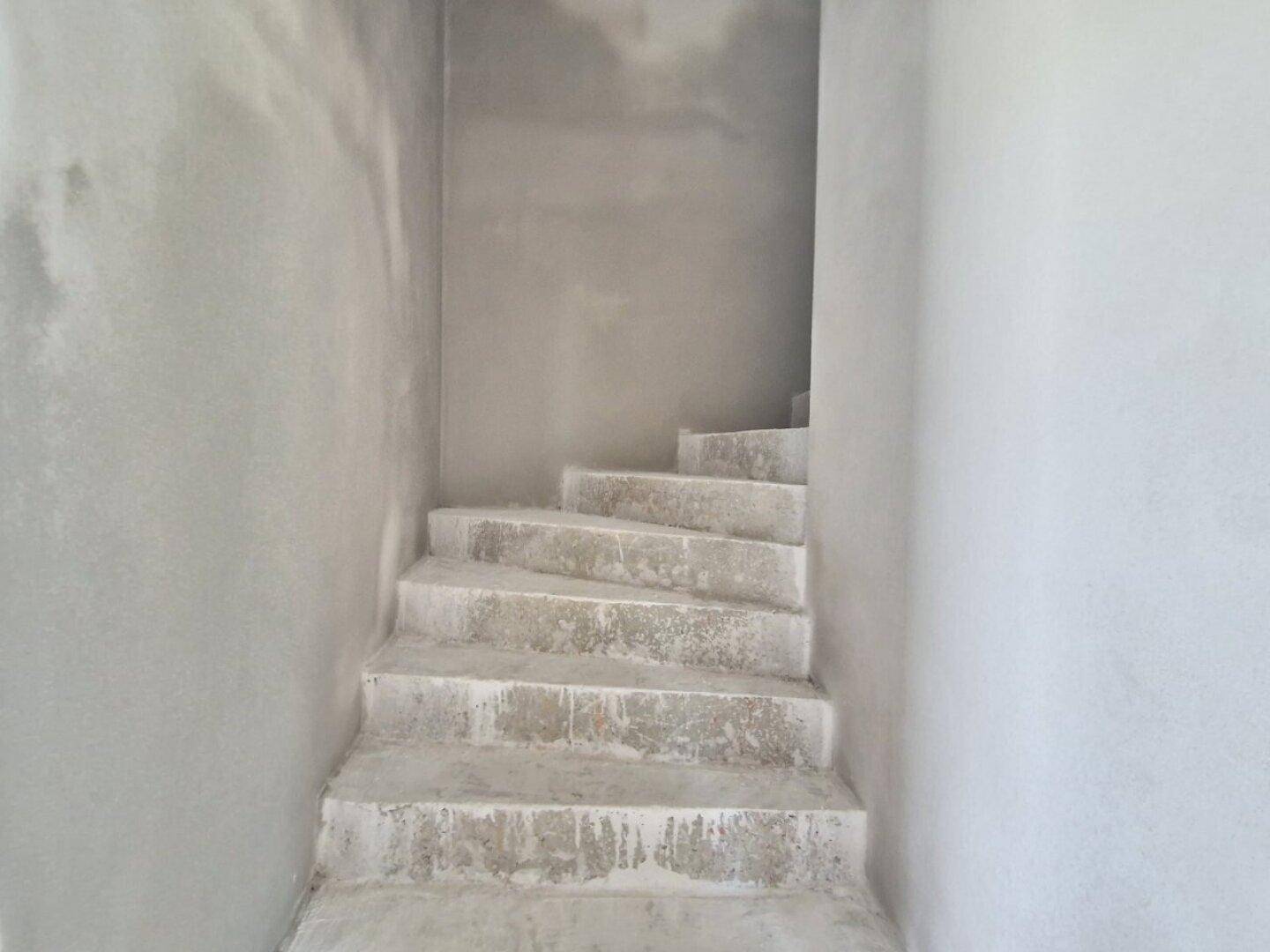 Unfertige Betontreppe in einem Rohbau-Flur, bereit für die Verkleidung.