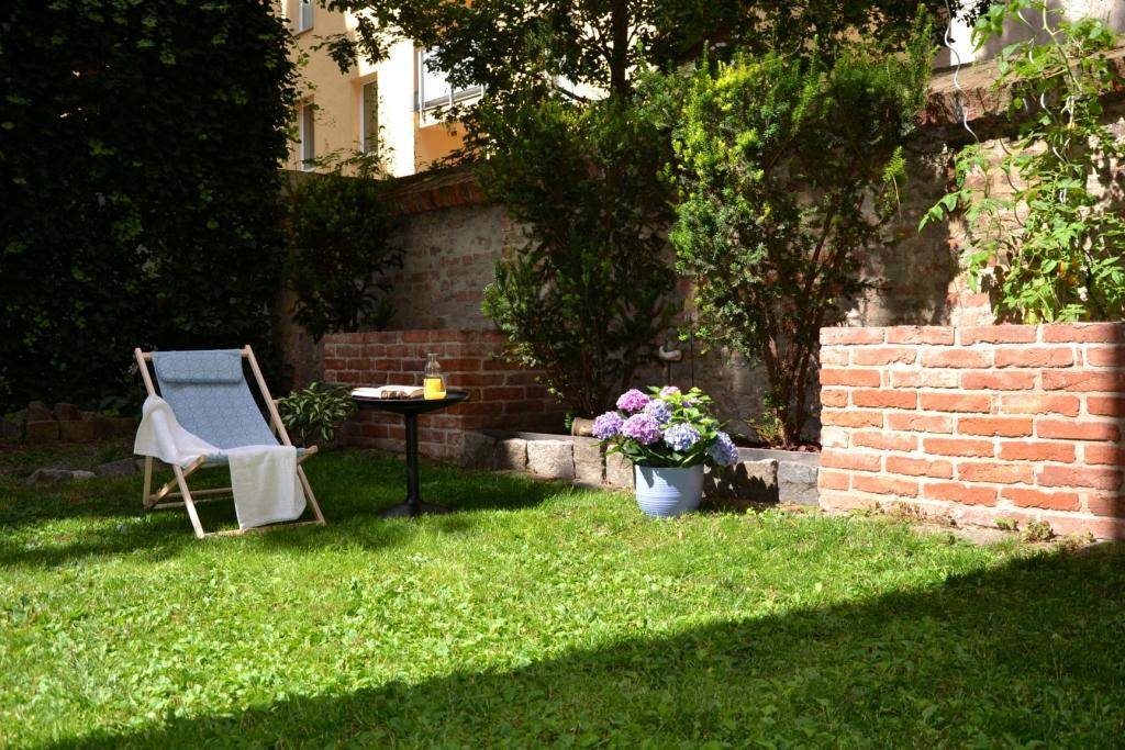 Sonnige Gartenoase mit Liegestuhl, Tisch und blühenden Hortensien.