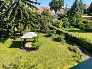 Erhöhte Ansicht des Gartens mit Pavillon, Rasen und Hecken, bietet einen weiten Blick über die Umgebung.