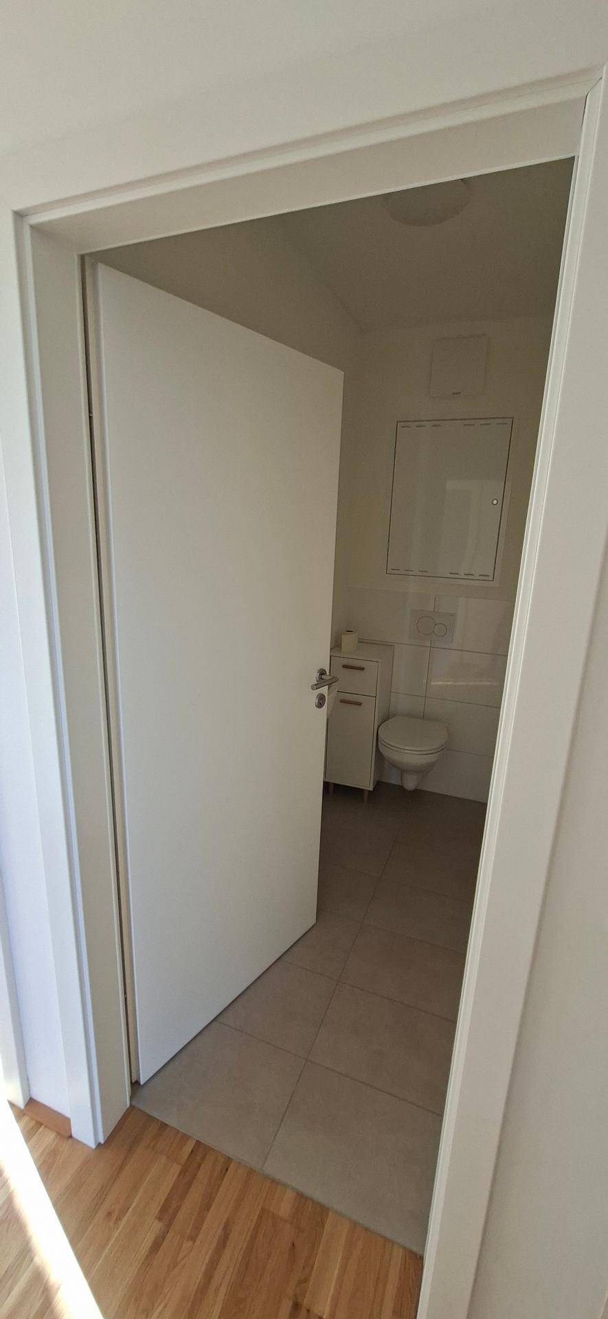 Separates Gäste-WC mit Fliesenboden und wandhängendem WC, praktisch und funktional gestaltet.
