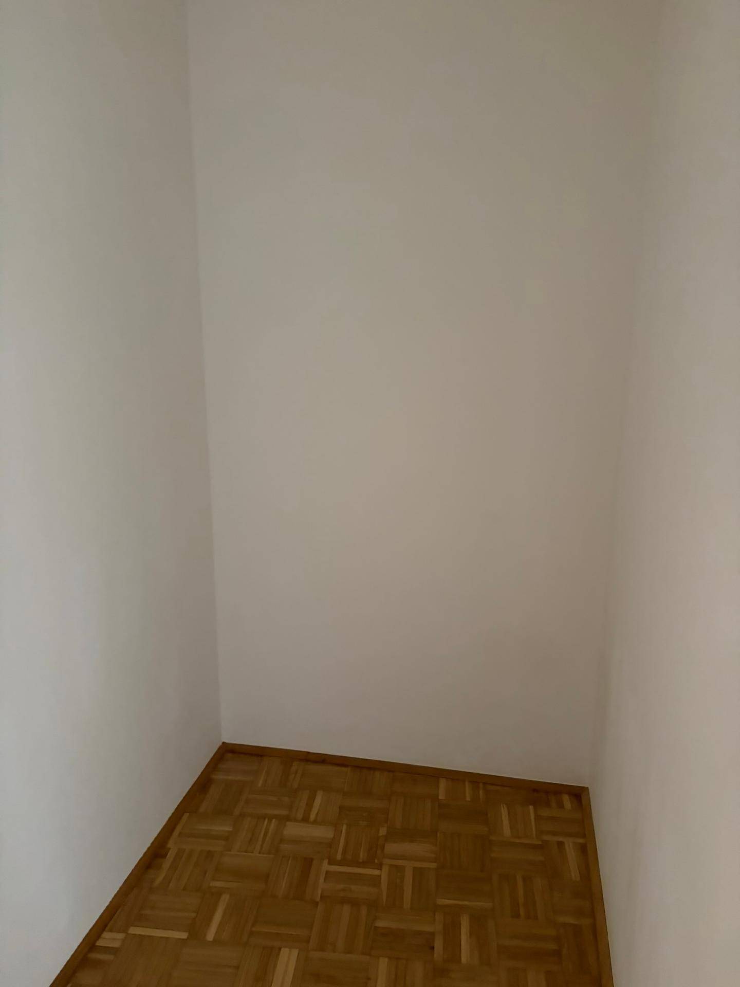 Kleiner, leerer Raum mit Parkettboden und weißen Wänden, ideal als Abstellraum nutzbar.