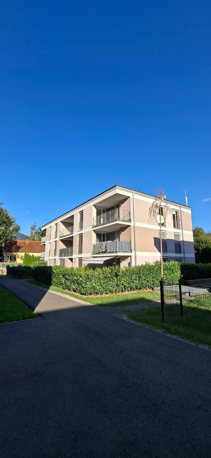 Modernes Mehrfamilienhaus mit ansprechender Architektur, Balkonen und gepflegter Grünanlage.