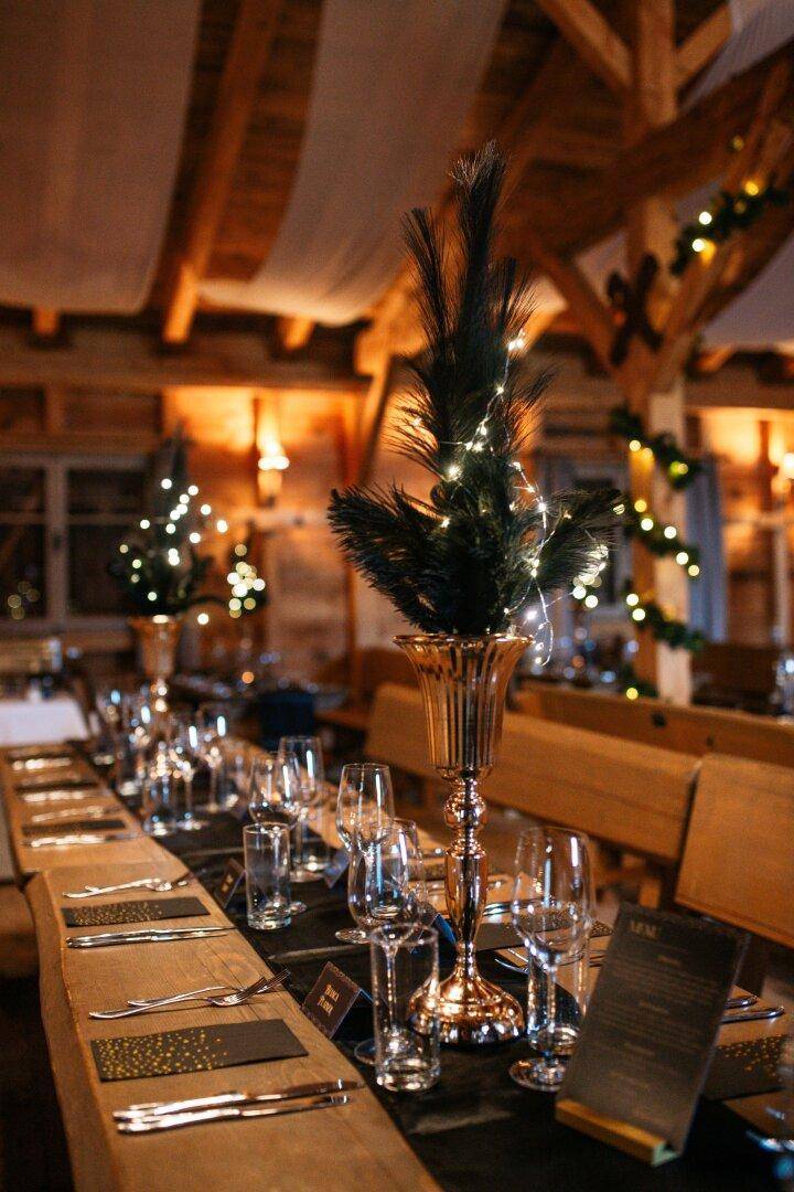 Festlich gedeckter Holztisch mit eleganten Dekorationen und Gläsern, bereit für ein Dinner.