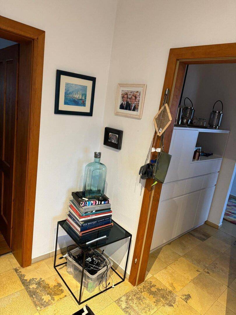 Eingangsbereich mit dekorativen Elementen, Holzrahmen und hellem Steinboden.