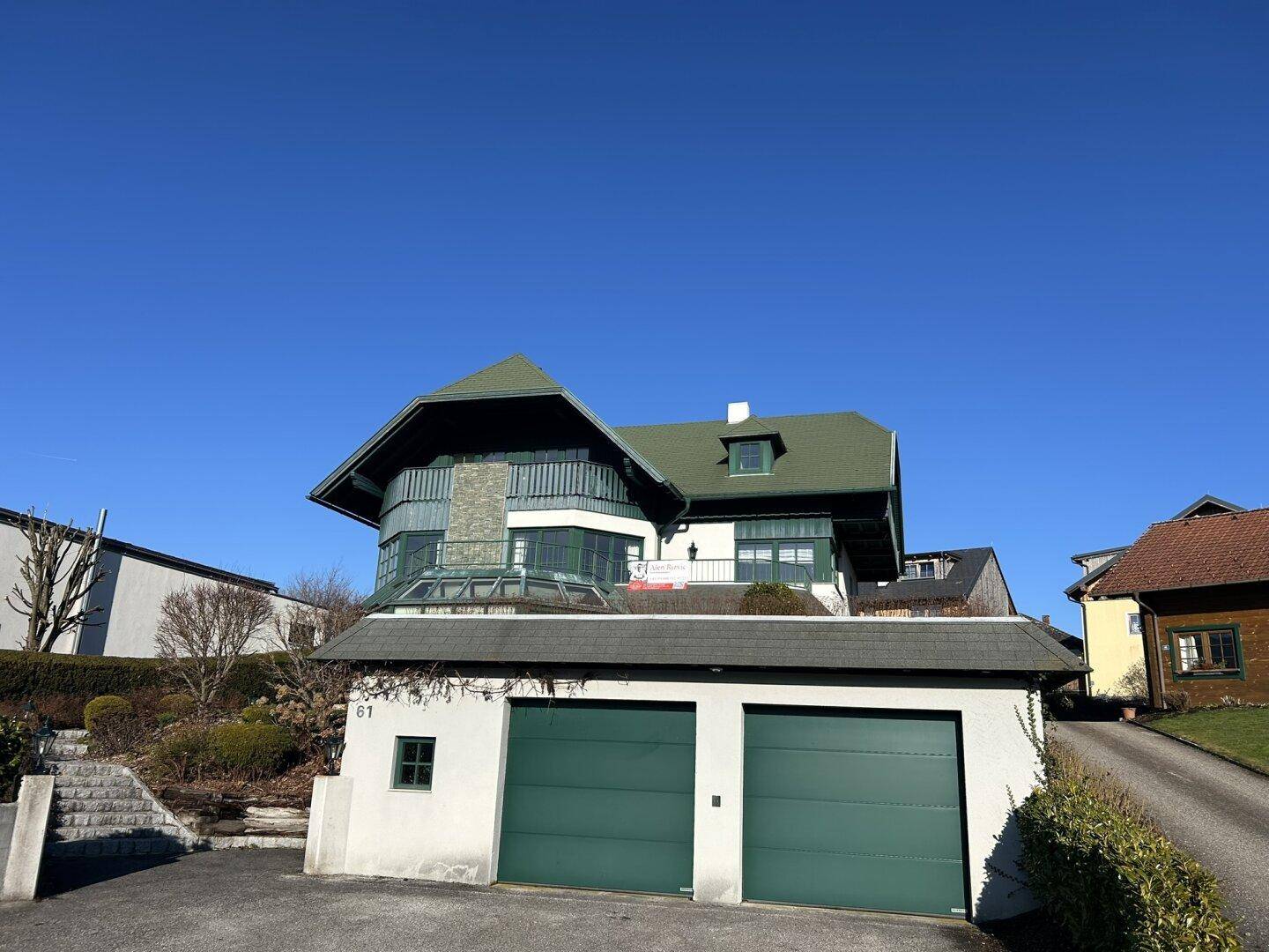 Ansicht des Hauses von der Straße mit Doppelgarage und gepflegter Zufahrt.