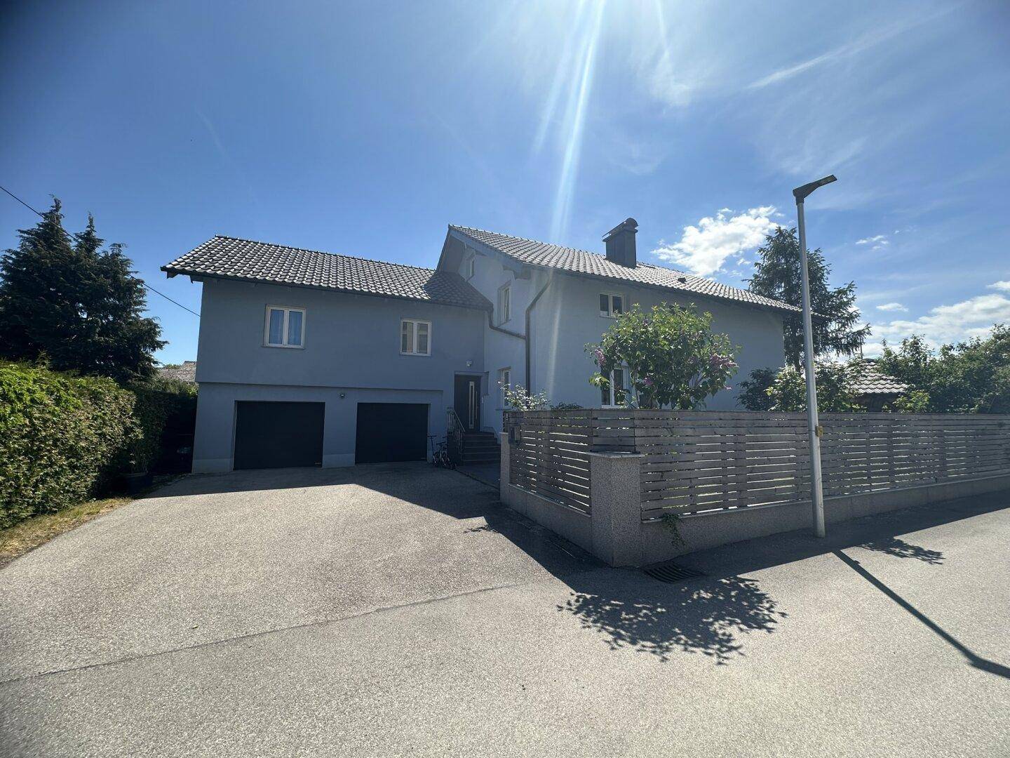 Vorderansicht des Hauses mit Einfahrt, Doppelgarage und gepflegtem Vorgarten.