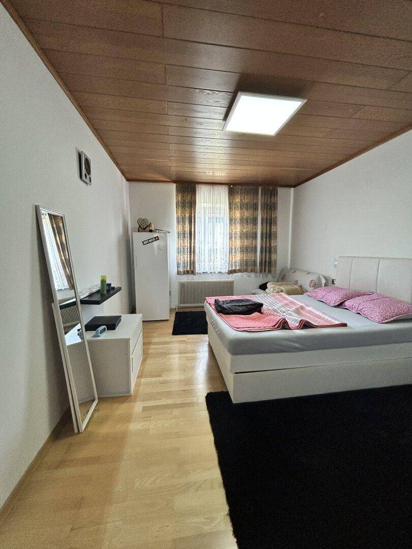Schlafzimmer mit Holzboden, Holzdecke und einem bequemen Doppelbett.