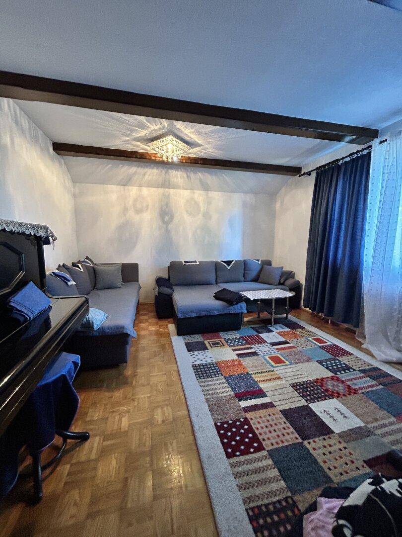 Geräumiges Wohnzimmer mit Holzboden, Holzdecke und zwei gemütlichen Sofas.