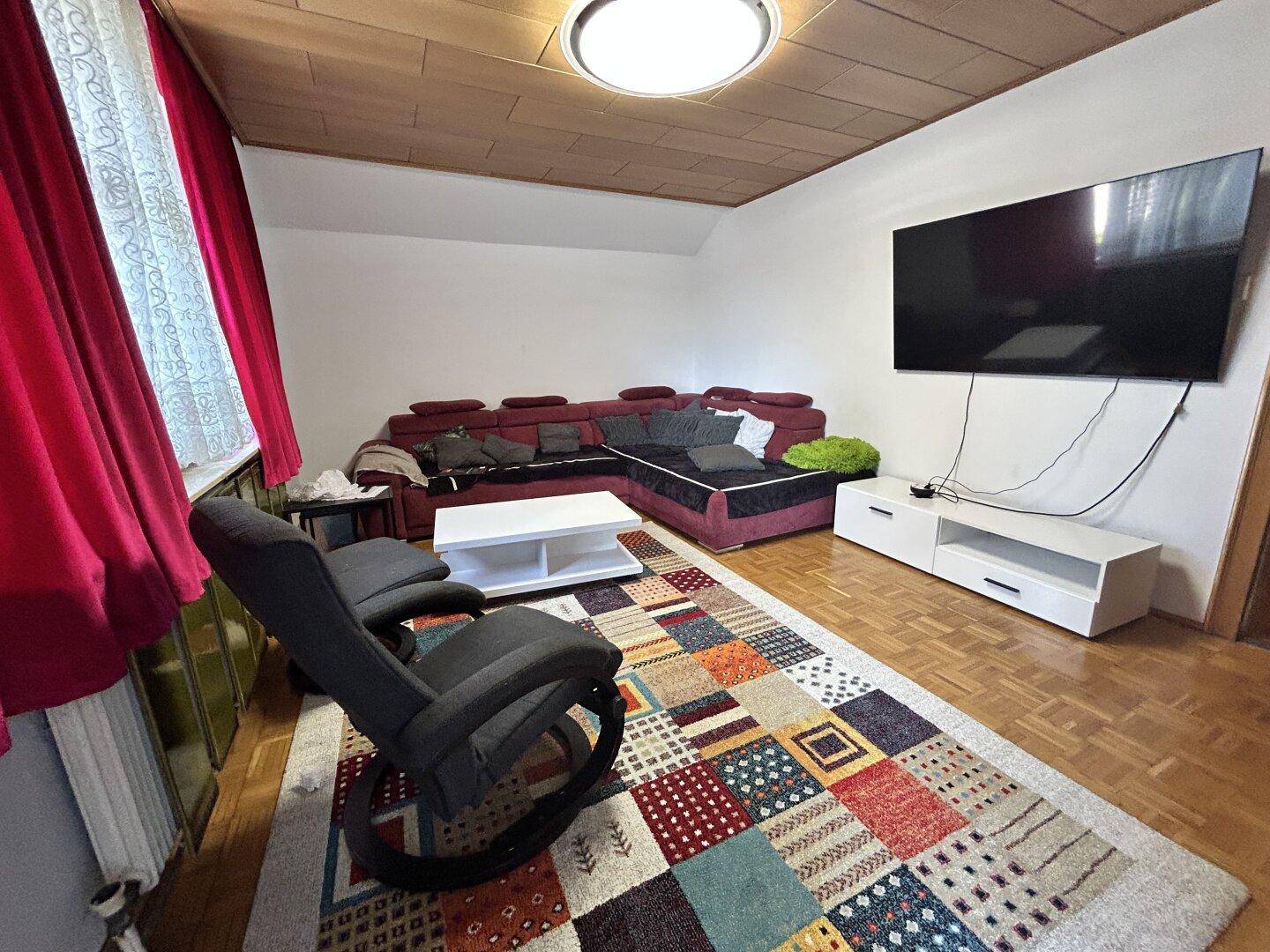 Wohnzimmer mit Holzboden, Holzdecke und einem großen Ecksofa für entspannte Abende.