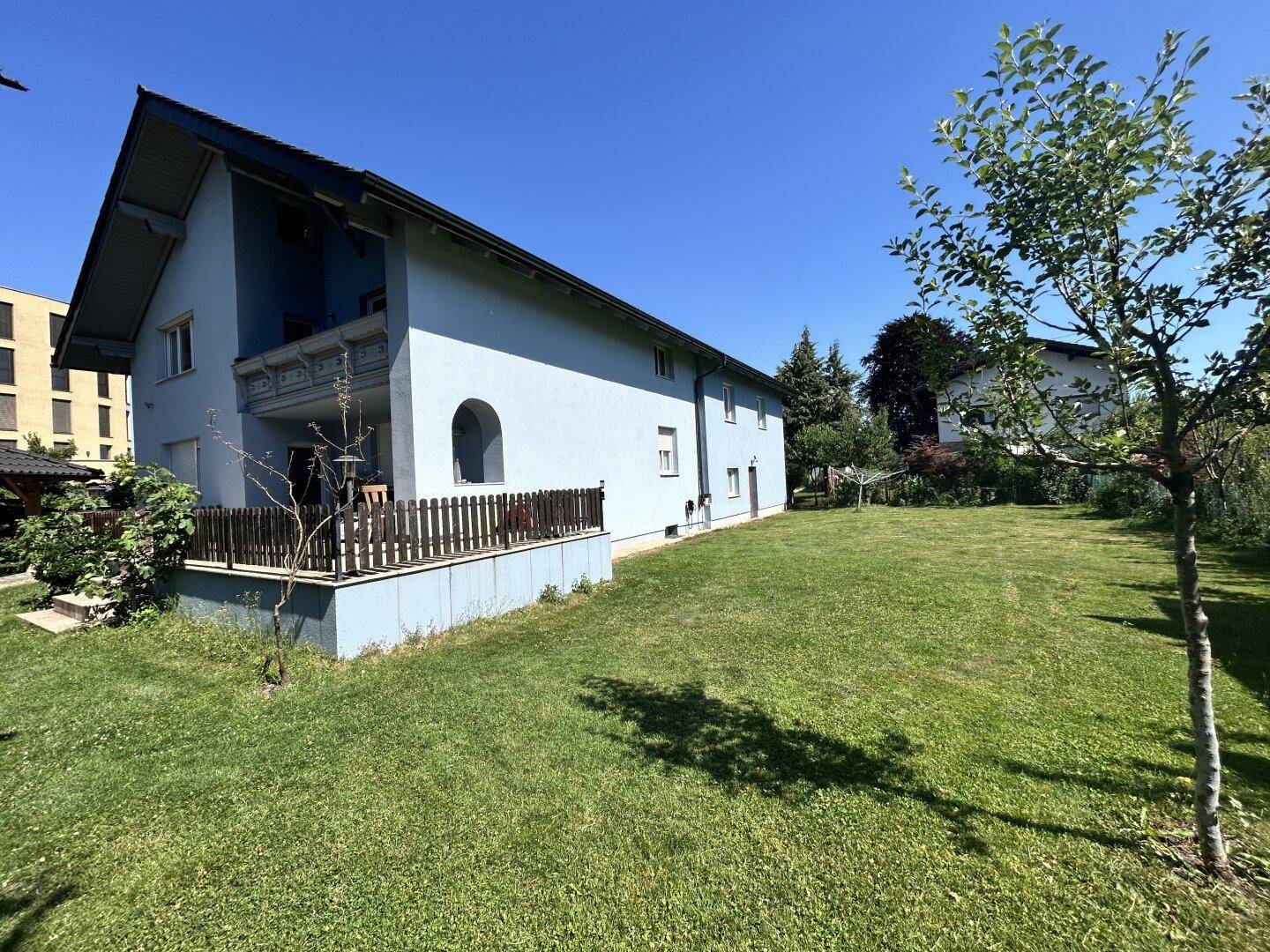 Seitenansicht des Hauses mit großem Garten und weitläufiger Rasenfläche.