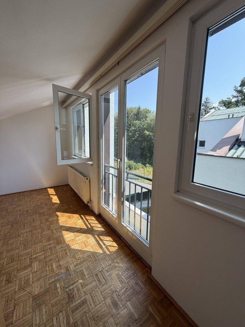 Große Fenster mit französischem Balkon bieten einen Blick ins Grüne und auf die Umgebung.