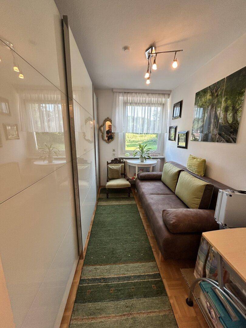 Kleines Zimmer mit Sofa, Einbauschrank und Fenster, ideal als Gäste- oder Arbeitszimmer.