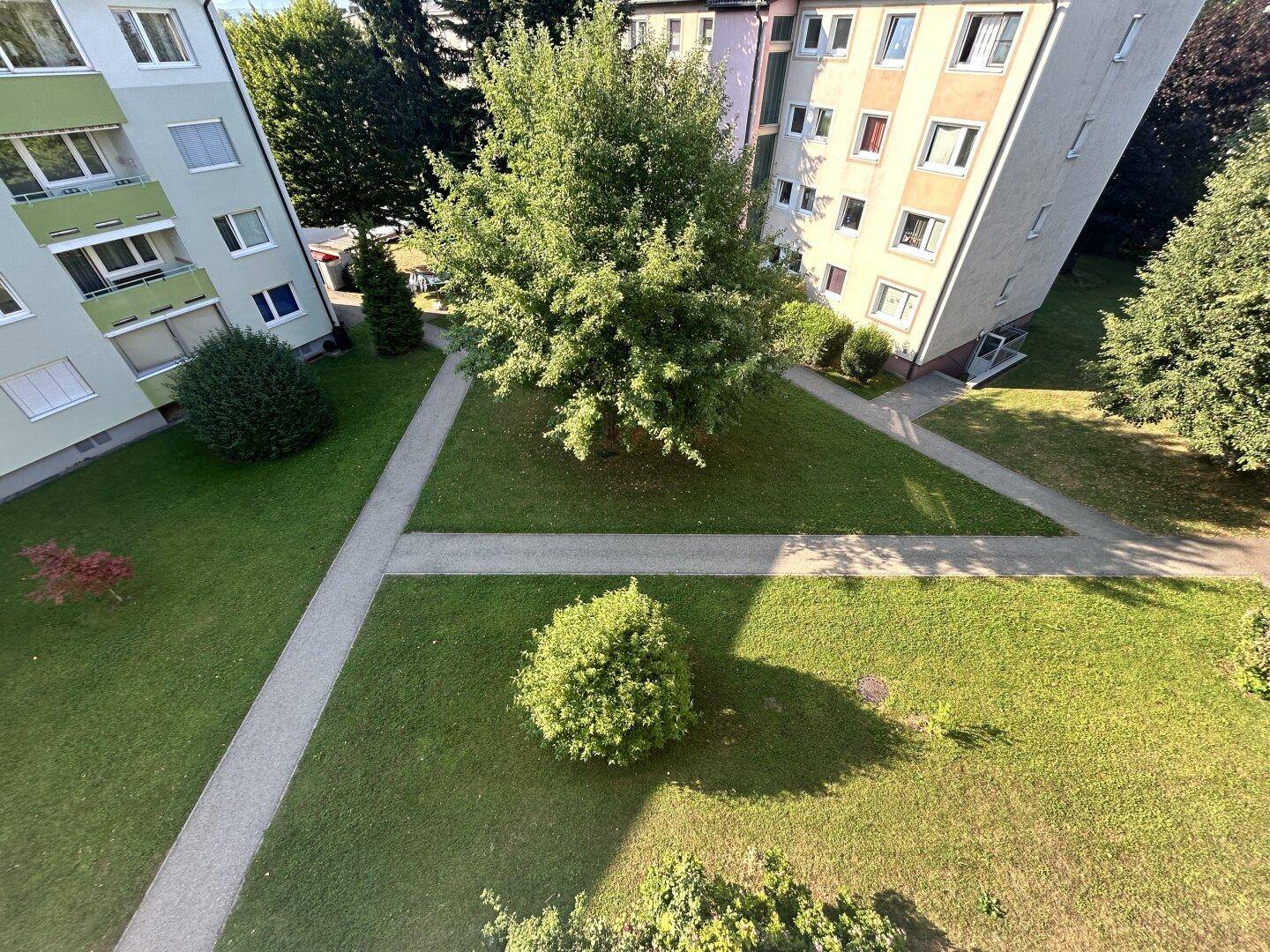 Gepflegte Grünflächen und Wege zwischen den Wohngebäuden der Siedlung.