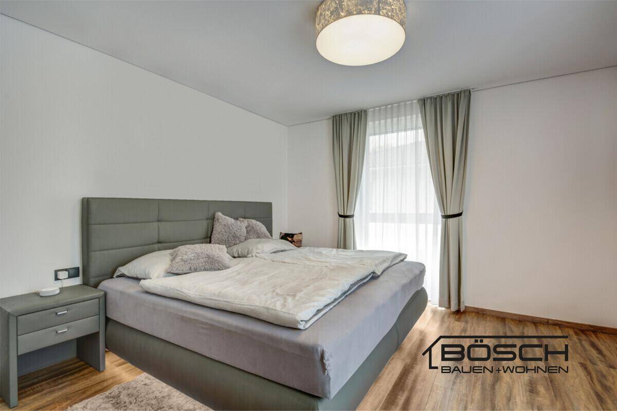Gemütliches Schlafzimmer mit großem Doppelbett, Nachttischen und hellem Laminatboden.