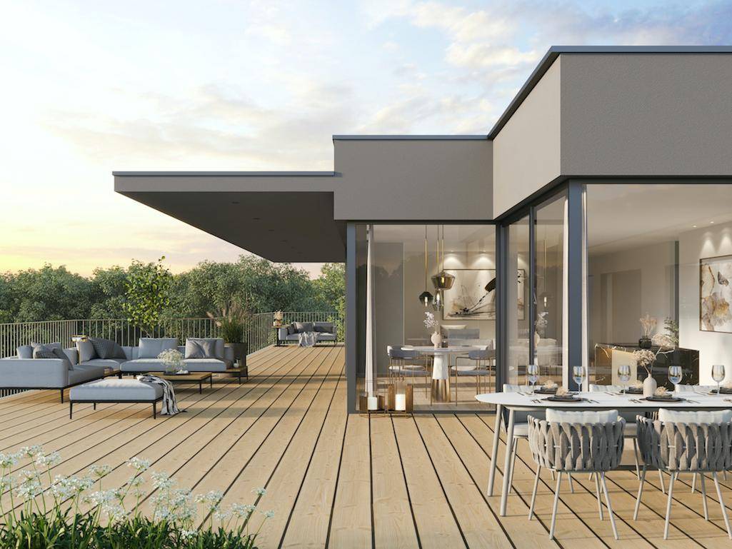 Weitläufige Holzterrasse mit Ess- und Loungebereich, umgeben von grüner Natur.