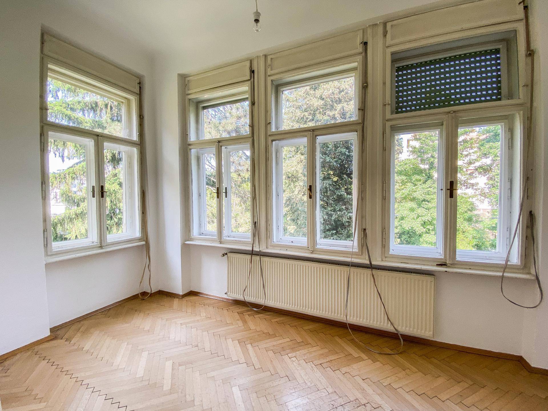 Heller Raum mit vielen Fenstern und Fischgrätparkett, der einen schönen Ausblick auf die Umgebung bietet.