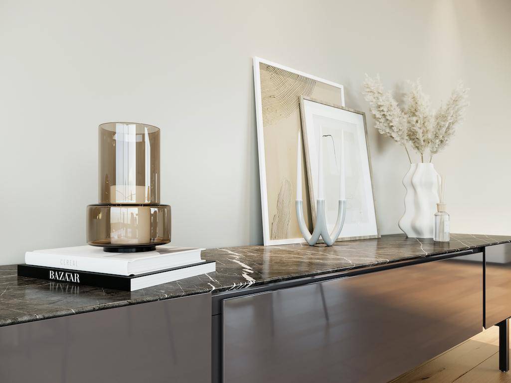 Detailaufnahme eines Sideboards mit Marmorplatte und stilvoller Dekoration.