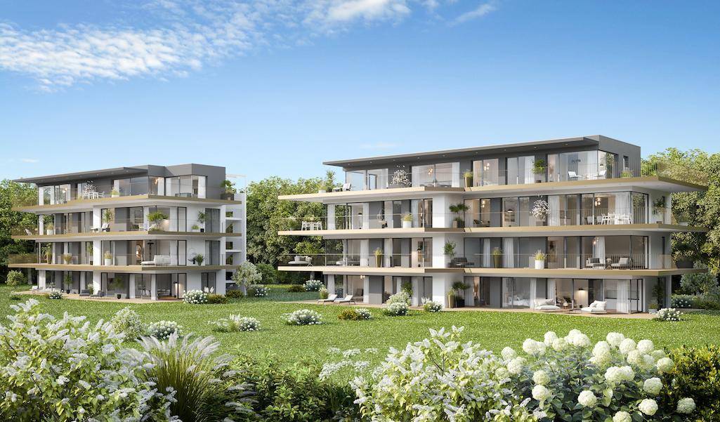Zwei moderne Mehrfamilienhäuser mit großzügigen Balkonen und Terrassen, eingebettet in eine grüne Landschaft.