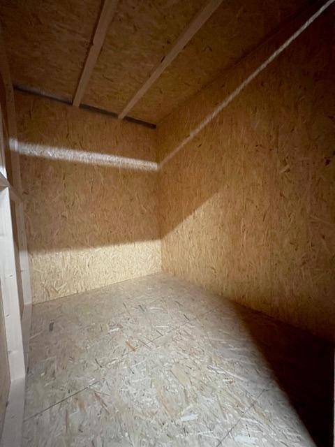 Leere Lagerbox mit Wänden und Decke aus hellen Holzspanplatten, bereit zur Nutzung.