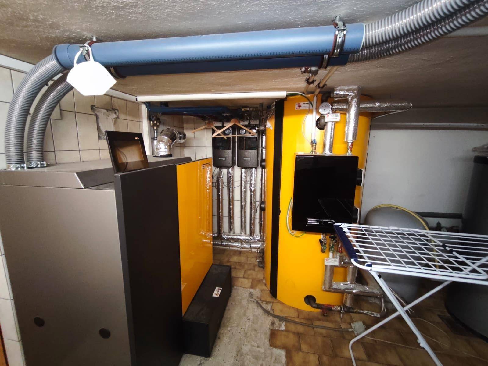 Heizungsraum mit modernen Heizkesseln und Warmwasserspeicher, gut organisiert und funktional.