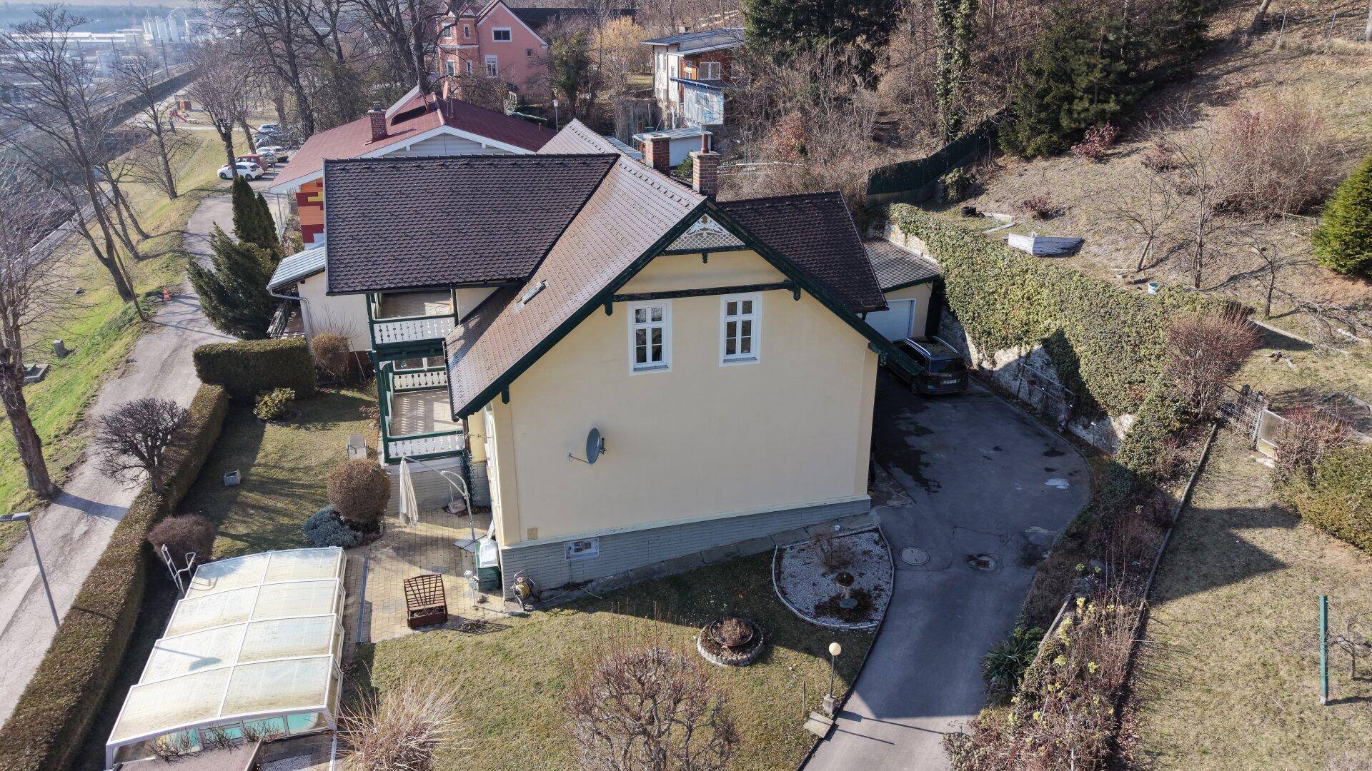 Seitenansicht des Hauses mit Zufahrt, Garten und Blick auf die Umgebung.