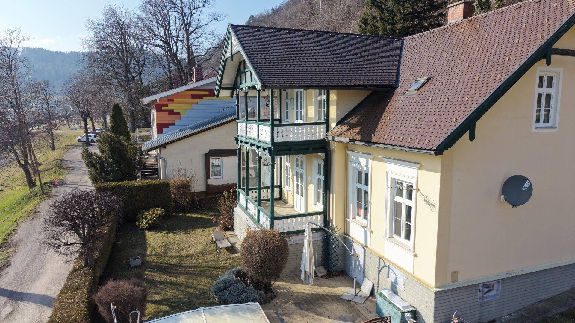 Seitenansicht des Hauses mit Garten, Terrasse und Blick auf die bergige Landschaft.