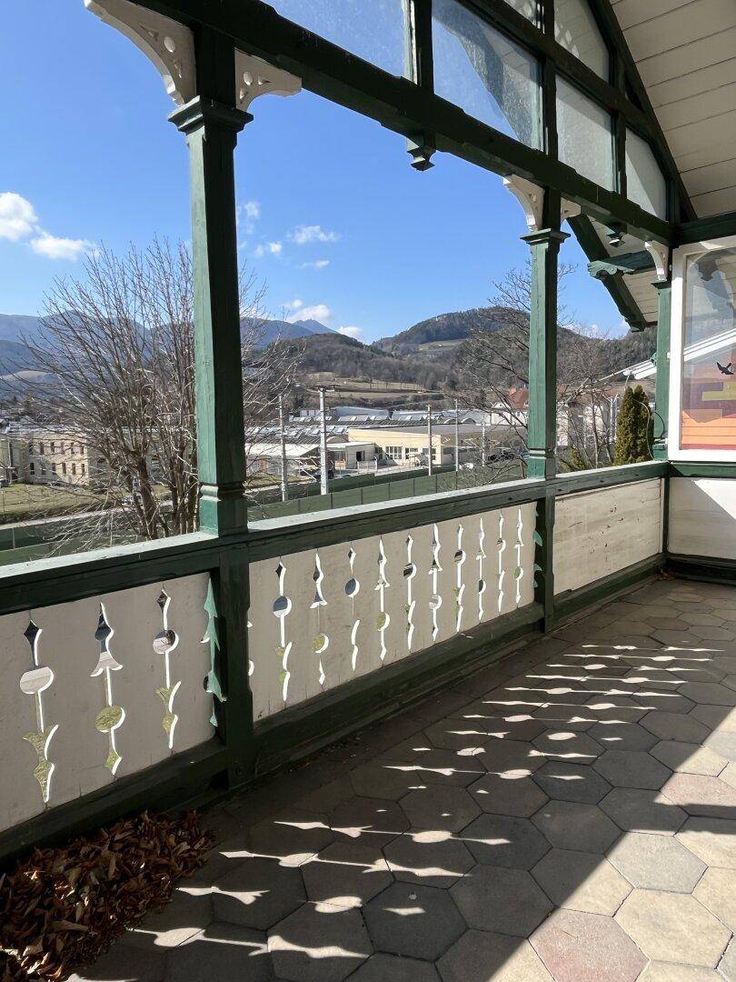 Balkon mit Fliesenboden und weitem Blick auf die umliegende Berglandschaft.