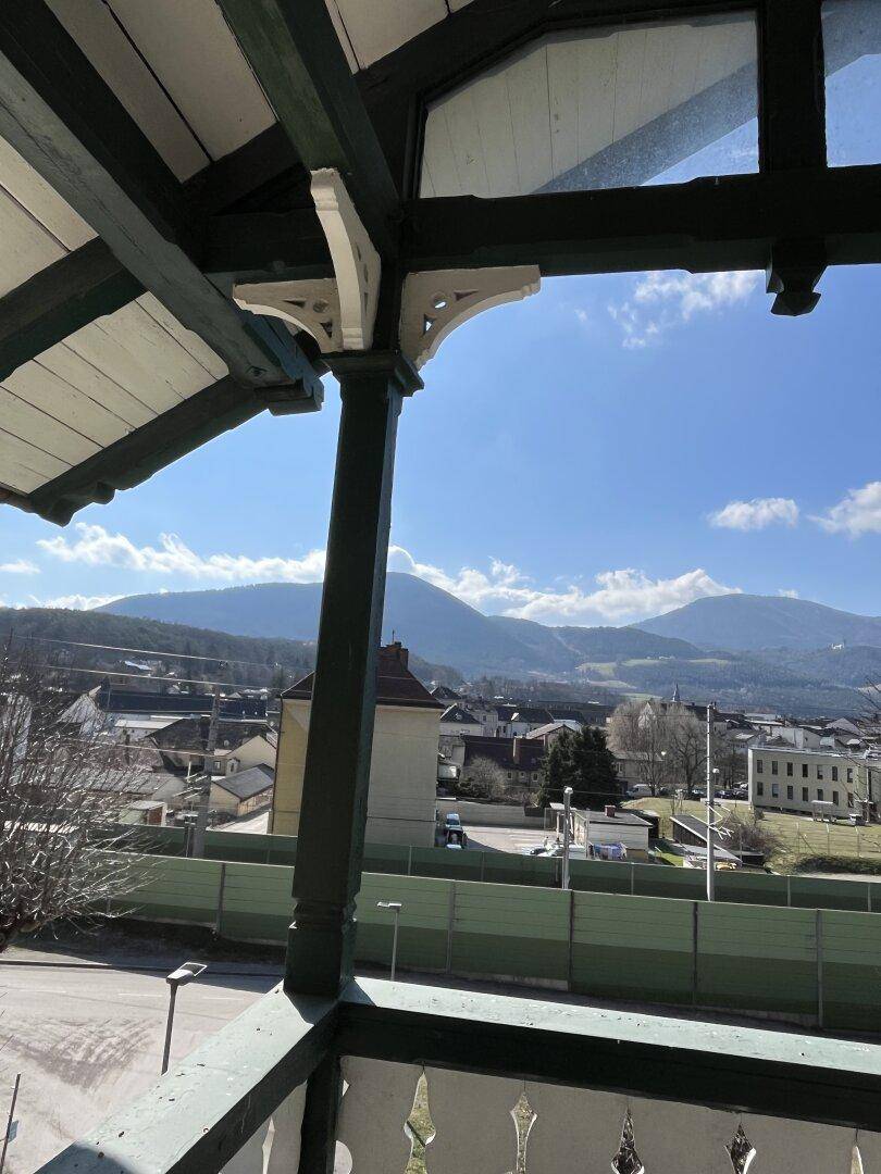 Balkon mit Panoramablick auf die Berge und die darunter liegende Stadt.