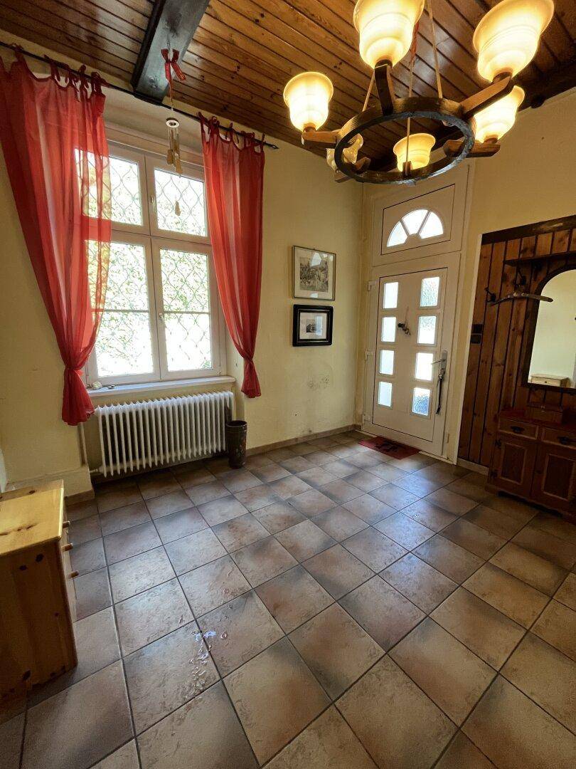Geräumiger Eingangsbereich mit Fliesenboden, Holzdecke und traditioneller Beleuchtung.