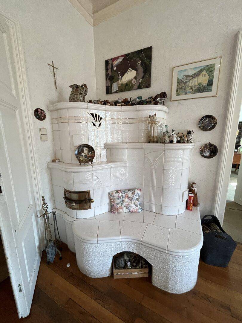 Gemütliches Wohnzimmer mit traditionellem Kachelofen und Holzboden.