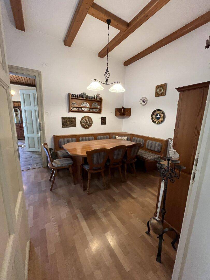 Rustikales Esszimmer mit Holzbalkendecke, Eckbank und Holzboden.