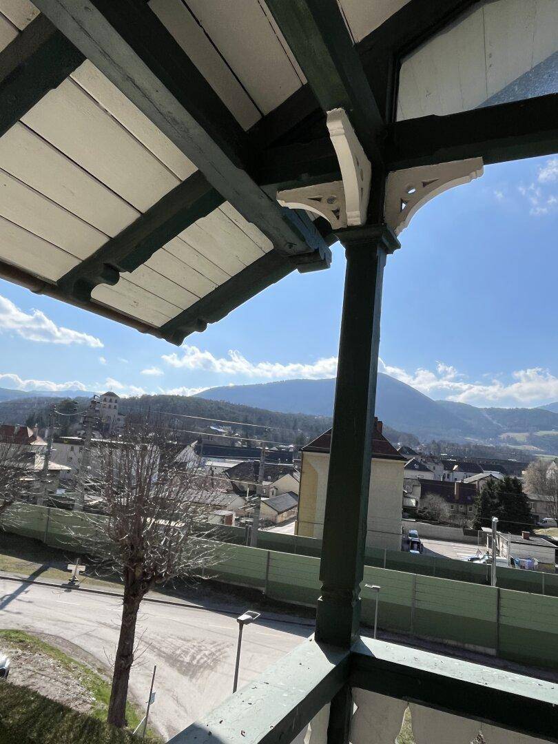 Balkon mit Panoramablick auf die Berge und die darunter liegende Stadt.