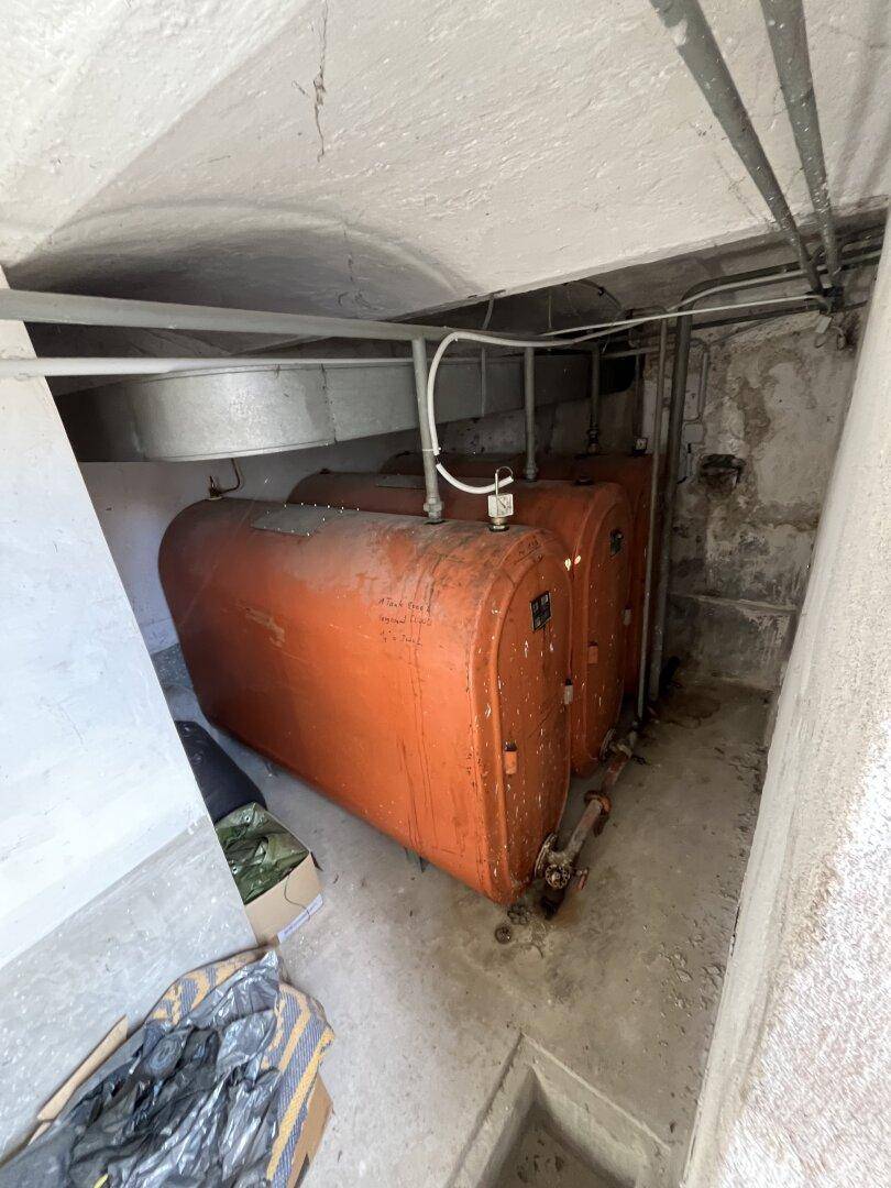 Heizungsraum im Keller mit Öltanks und Rohrleitungen.