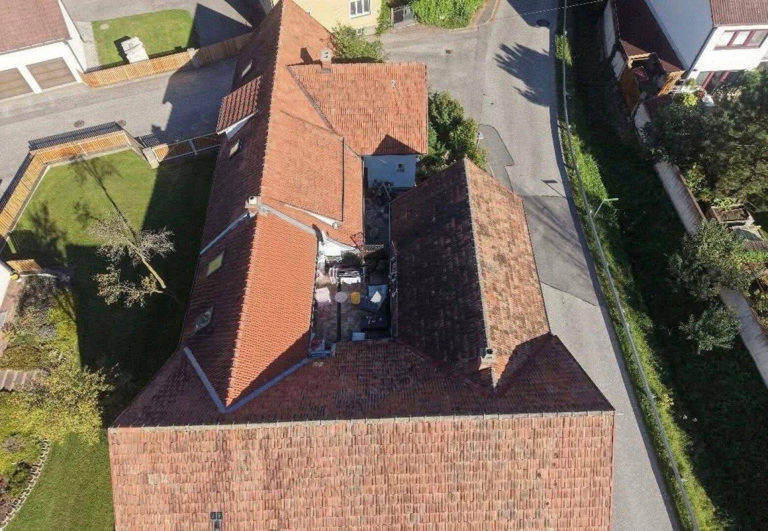 Luftaufnahme des Anwesens mit roten Ziegeldächern und der umliegenden Landschaft.