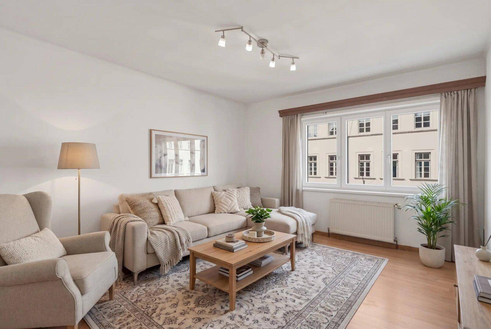 Gemütliches Wohnzimmer mit beigem Sofa, Holztisch und Teppich, hell und modern eingerichtet.
