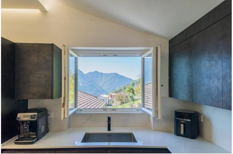 Moderne Küche mit Fenster, das einen malerischen Blick auf die Berge bietet.