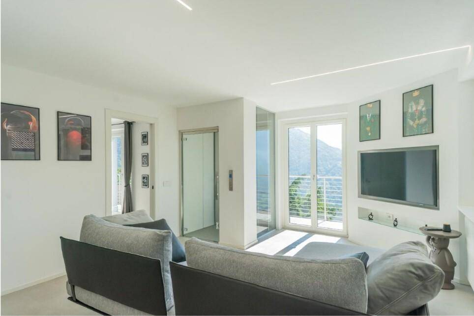 Heller Wohnbereich mit Zugang zum Balkon, Bergblick und integriertem Aufzug.