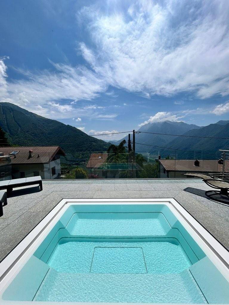 Nahaufnahme des modernen Whirlpools auf der Terrasse mit weitem Blick auf die Berge.