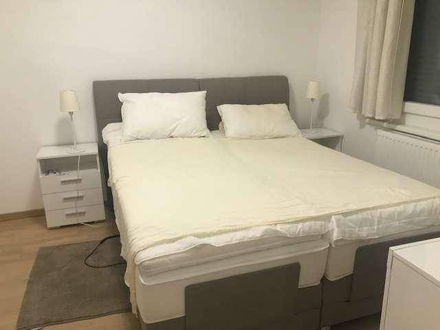 Schlafzimmer mit Doppelbett, Nachttischen und Lampen, bereit für eine erholsame Nacht.