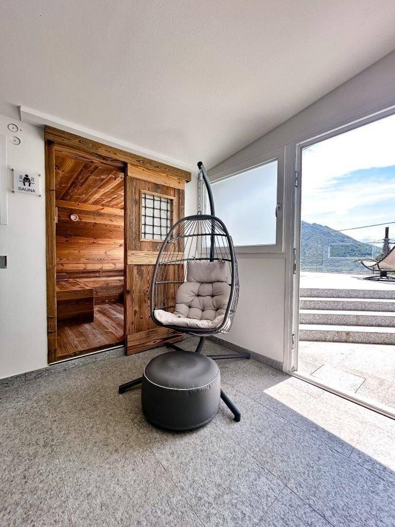Heller Raum mit Zugang zur Sauna und einem bequemen Hängesessel zum Entspannen.
