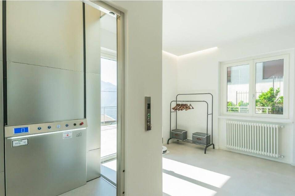 Moderner Aufzug im Innenbereich mit viel Tageslicht durch ein großes Fenster.