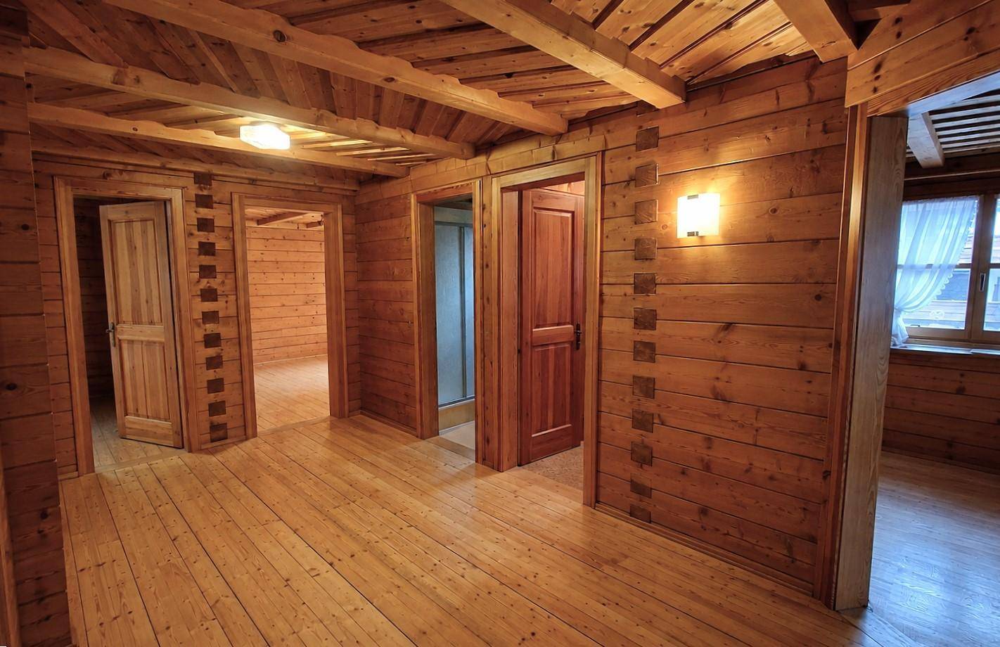Geräumiger Flur mit Holzboden, Holzvertäfelung und mehreren Türen zu angrenzenden Räumen.